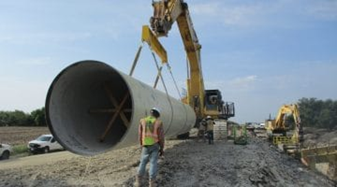 Large-diameter pipe being handled in the field